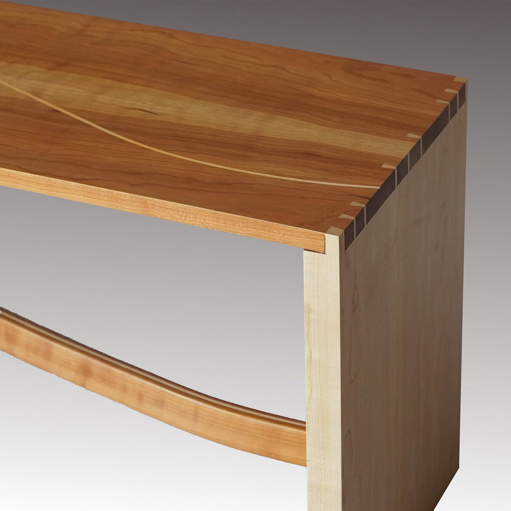 Bench of solid maple and cherry with dovetailed joinery, maple inlay and a curved rail